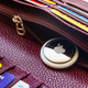 An apple AirTag inside a the zipper of a wallet.